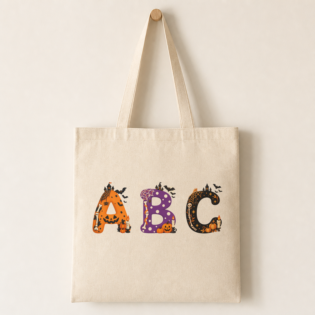 Plain canvas tote bag with several Mina characters printed across the front, including the mini pumpkins and candle detail at the bottom-right.