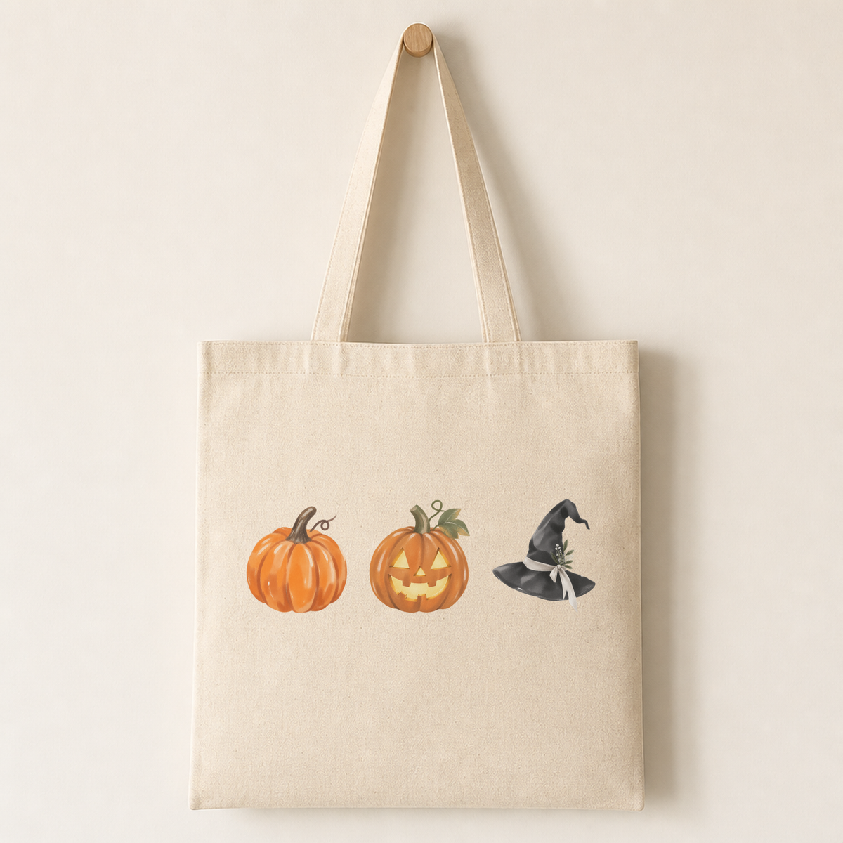 Plain canvas tote bag printed with a selection of the Halloween characters, showing pumpkins, witch hats and crescent moons with {accent} trim.