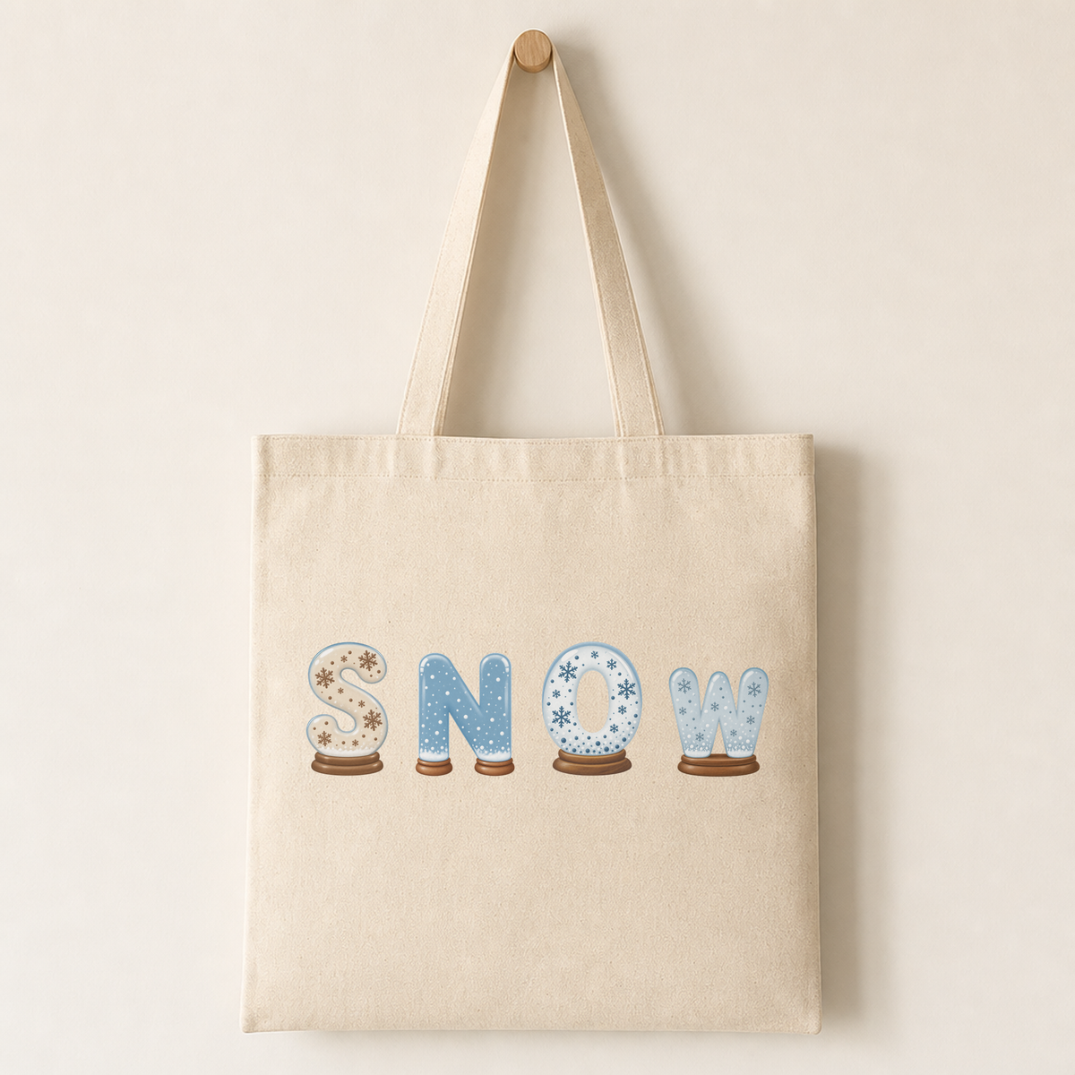 Canvas tote bag with a snow globe letter printed on the front, illustrating how the design looks on fabric.