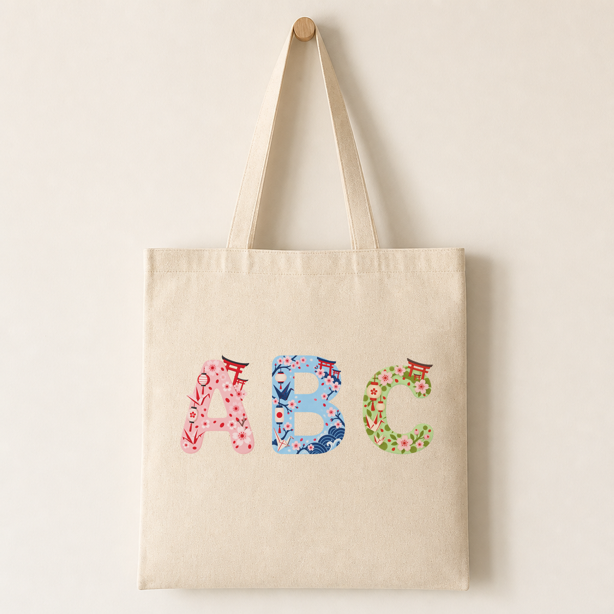 Canvas tote bag printed with a bold cherry blossom letter design and red torii accent