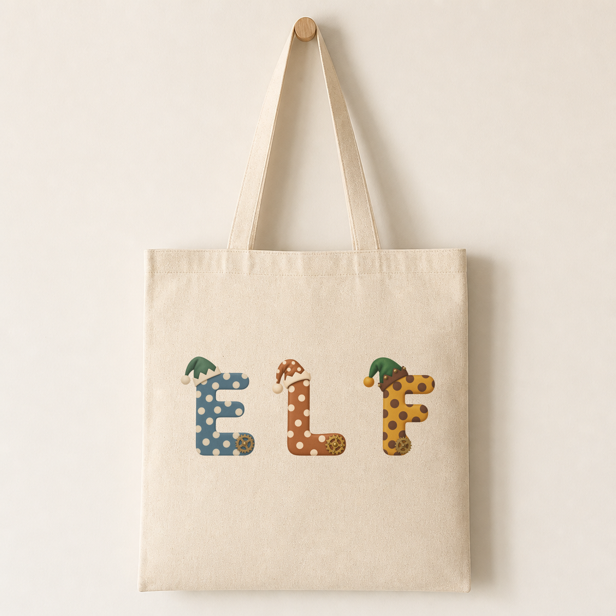 A natural canvas tote bag printed with a striped elf workshop letter character, showing how the design looks on fabric.