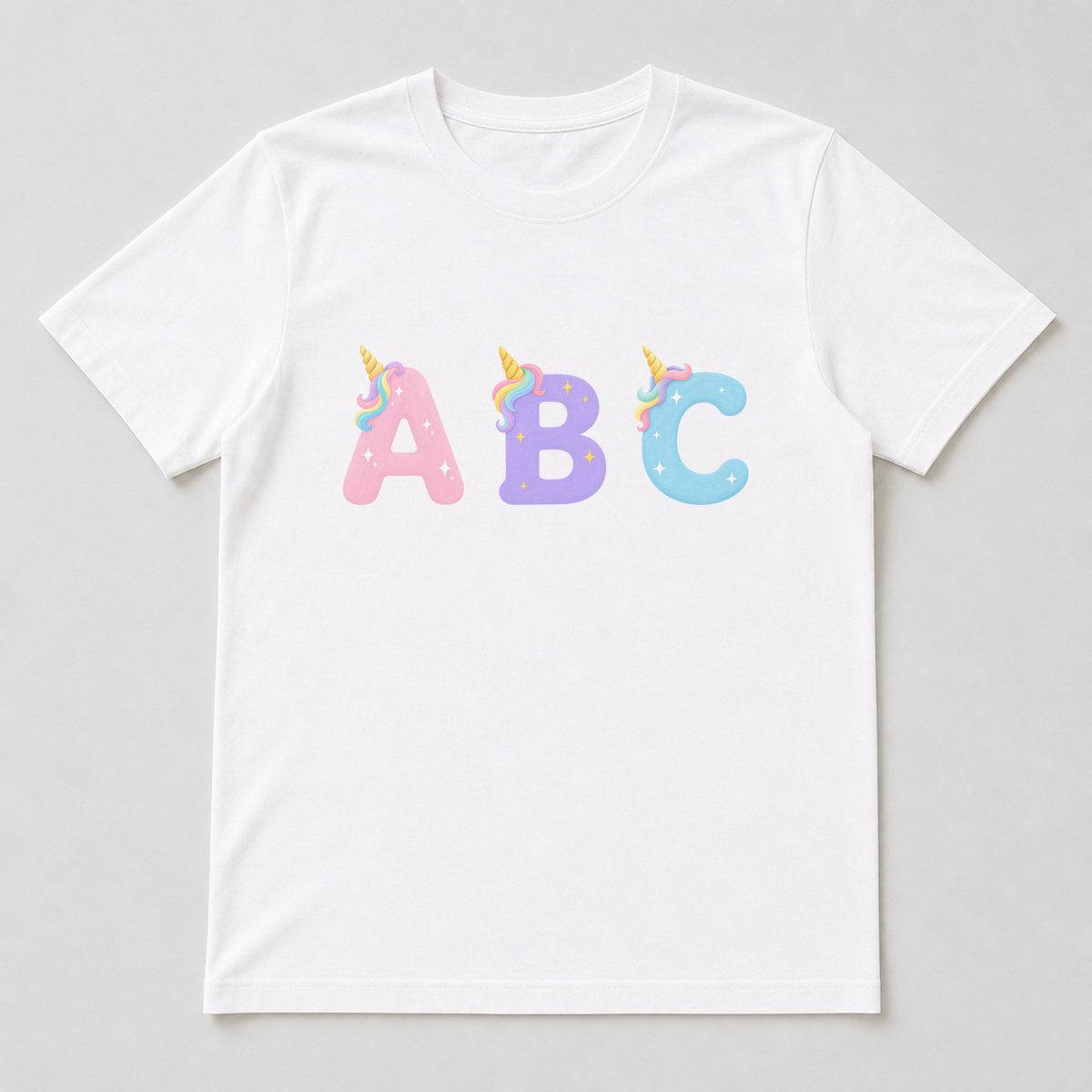 A white t-shirt with a unicorn capital letter printed on the chest, featuring the gold horn, pastel rainbow tuft and star sparkles.