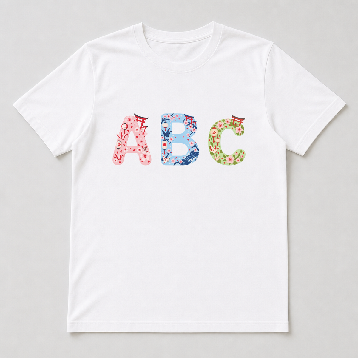 White t-shirt with a large printed letter featuring blossoms, torii and origami crane details